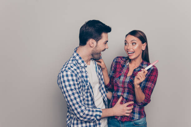 Studio photo portrait of she her he handsome cheerful rejoicing delightful bearded guy touching stomach abdomen on his sweet cute lovely dreamy wife looking at striped isolated grey background